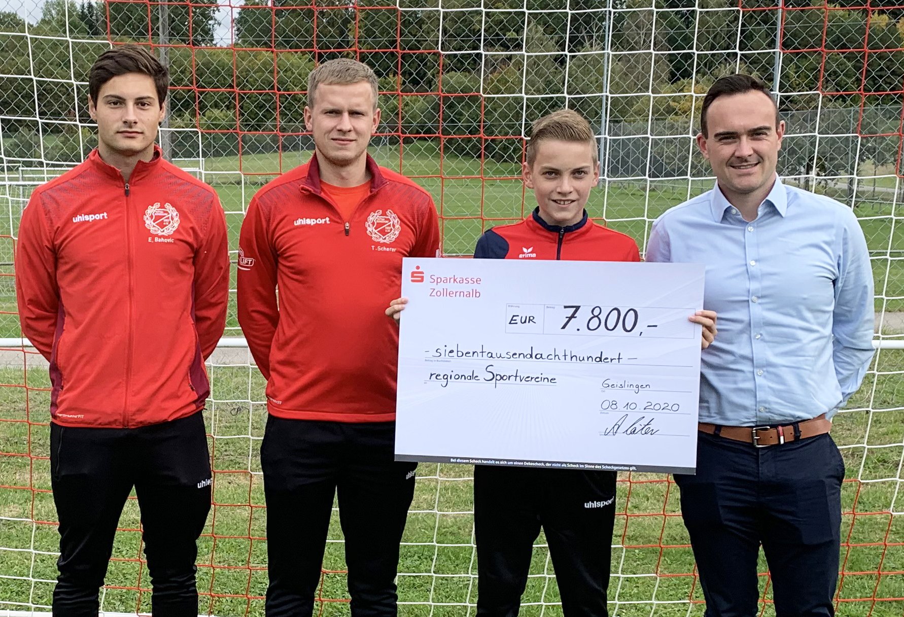 Spendenscheck über 7.800 Euro für regionale Sportvereine: Betreuer und ein Jugendspieler der SGM Geislingen/Erlaheim/Binsdorf mit Daniel Krüger am Fußballtor