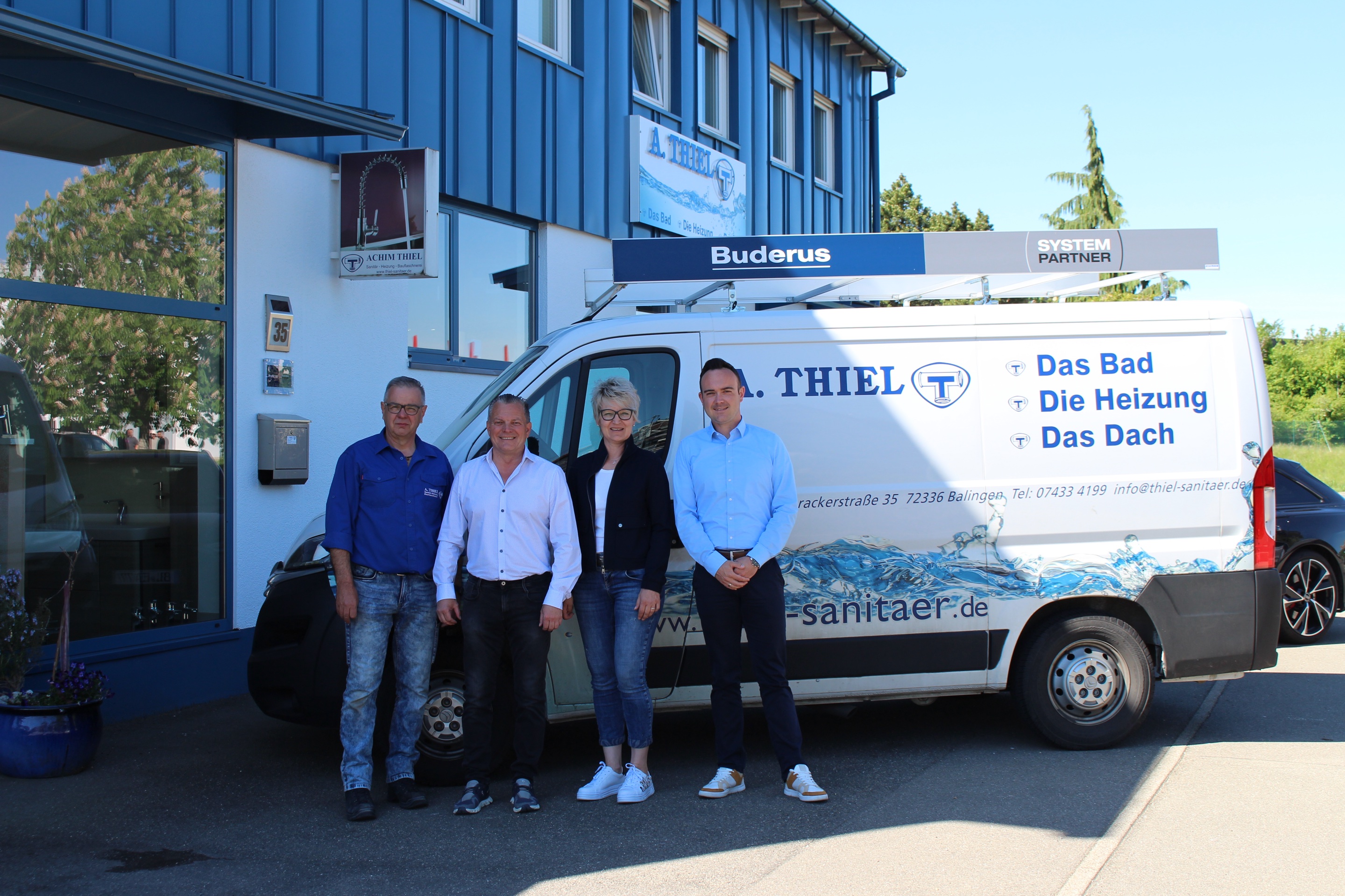 Vier Personen vor dem Firmengebäude von A. Thiel in Balingen, daneben ein Servicefahrzeug mit der Aufschrift „Das Bad, Die Heizung, Das Dach“