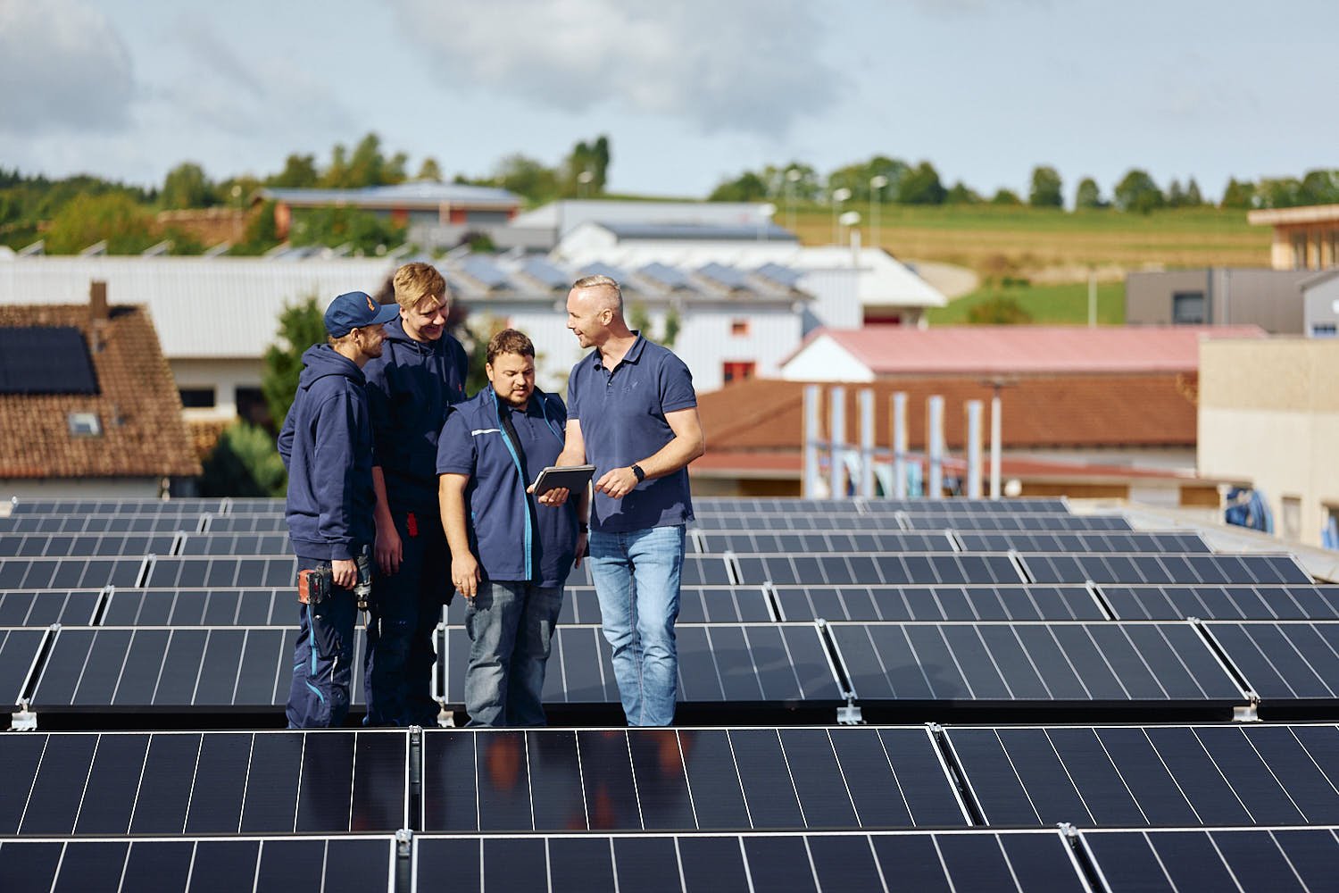 Team von EnergieAktiv bespricht sich auf einem Dach mit Photovoltaikanlage