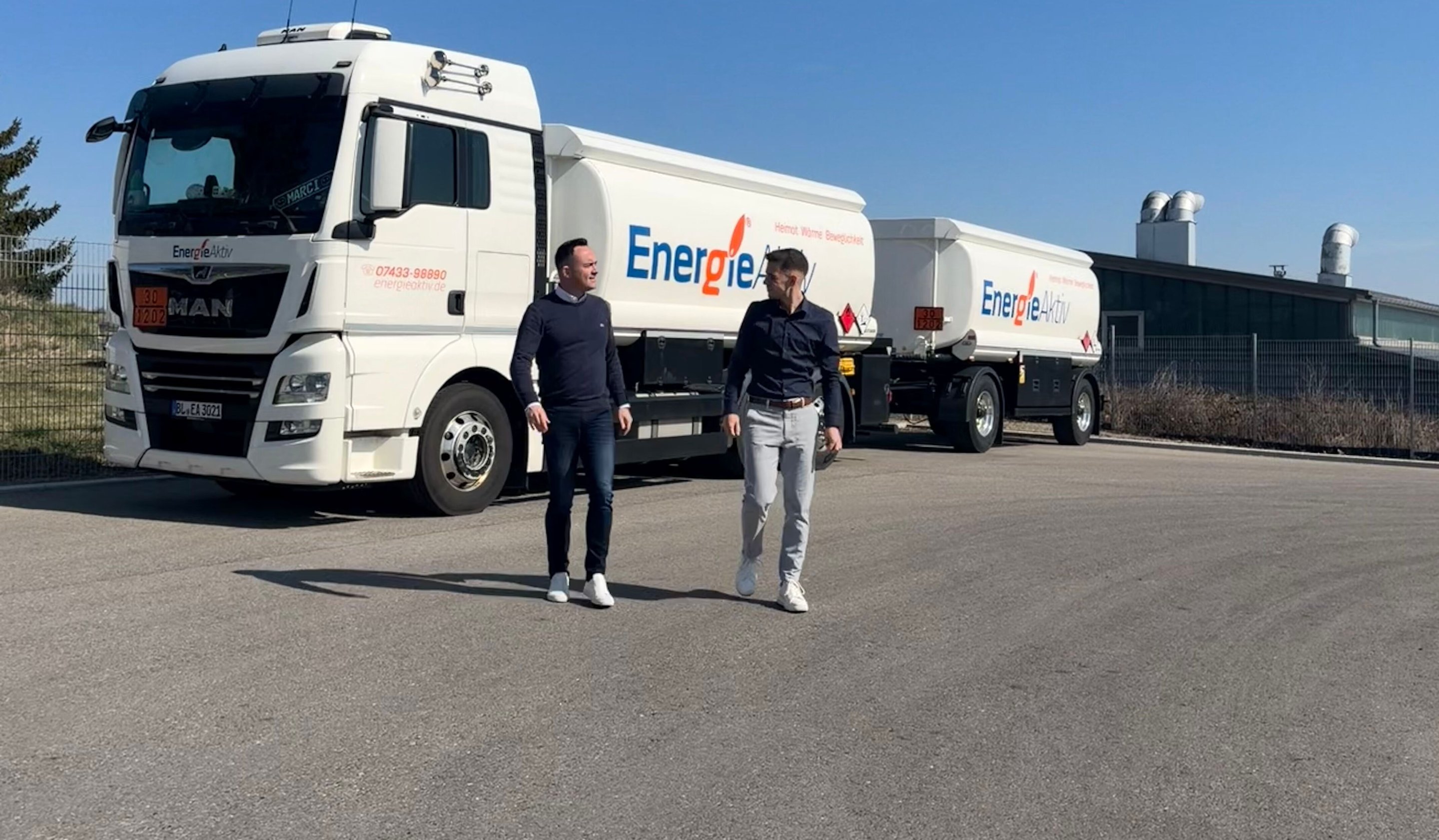 Die Geschäftsführer Daniel Krüger und Jannik Beiter vor einem EnergieAktiv-Tankzug auf dem Betriebshof
