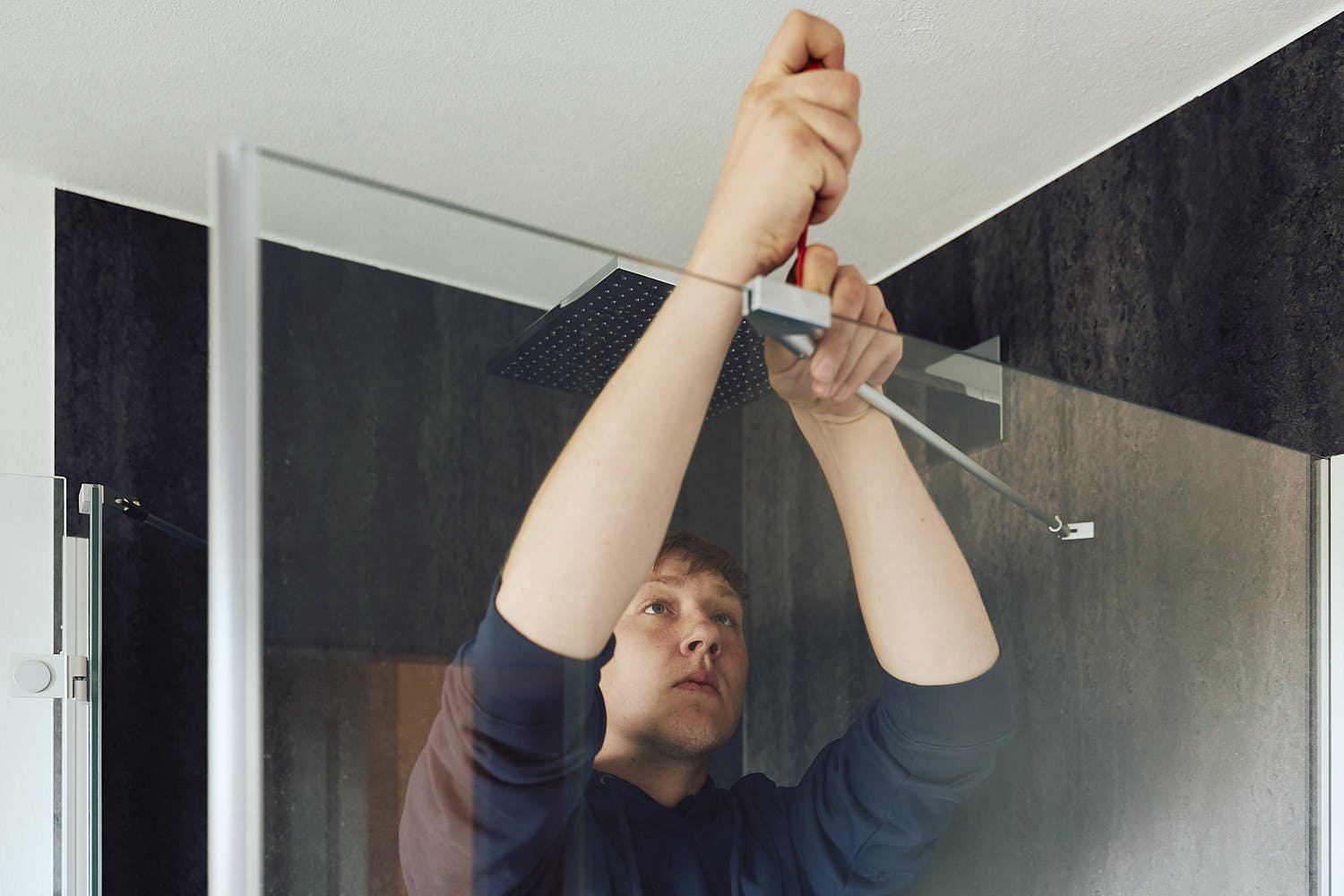 Monteur von EnergieAktiv montiert im Neubau eine Regendusche