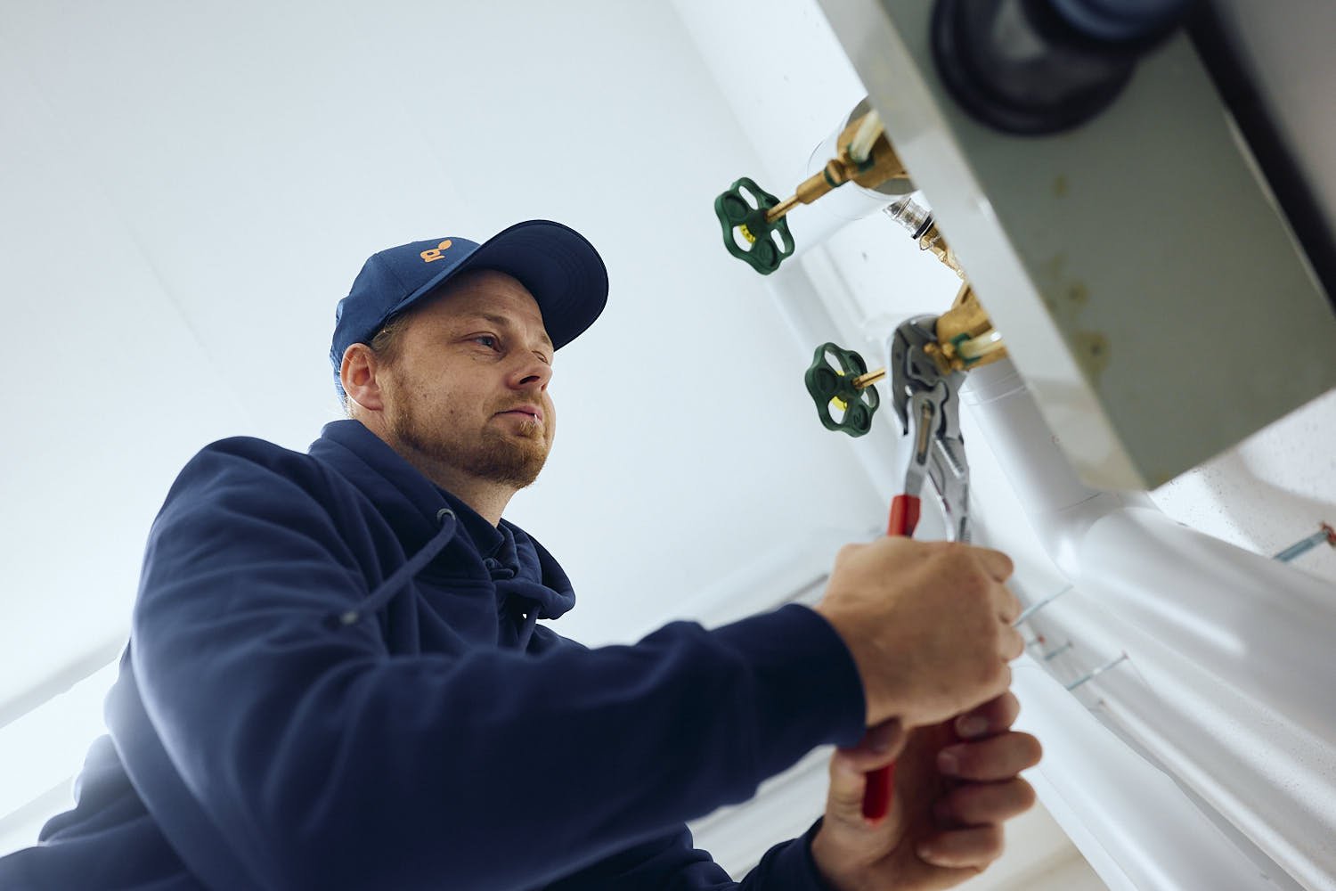 Monteur von EnergieAktiv schließt Ventile an einer Heizungsanlage an