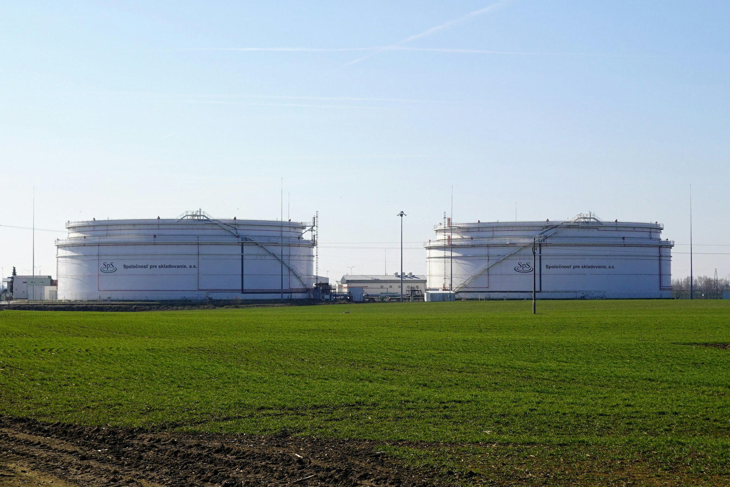 Zwei große weiße Lagertanks auf einer grünen Wiese